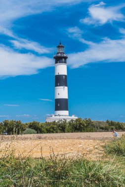 Fransa 'daki Oleron adasında mavi gökyüzünde siyah beyaz çizgili Chassiron deniz feneri.