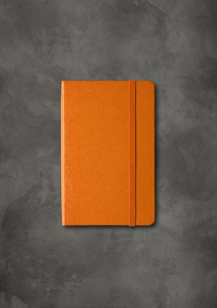 Oranje Gesloten Notebook Mockup Geïsoleerd Donkere Betonnen Achtergrond — Stockfoto