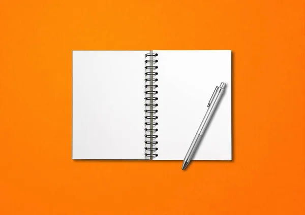 ブランクオープンスパイラルノートブックモックアップとペンはオレンジの背景に隔離 — ストック写真