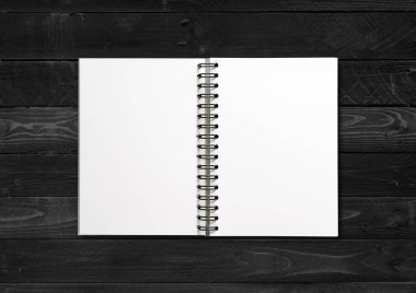 Boş spiral defter modeli siyah ahşap arka planda izole edildi