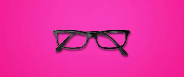 ピンクの背景のバナーに隔離された黒い目のメガネ — ストック写真