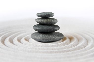 Siyah taşlar kuma yığılır. Zen Japon bahçe arka planı