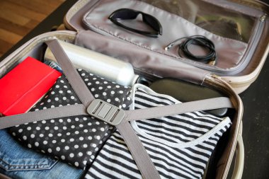 Giysilerle dolu eski model bir valiz.