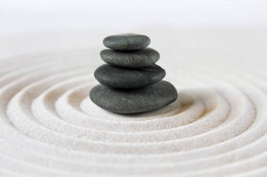 Siyah taşlar kuma yığılır. Zen Japon bahçe arka planı