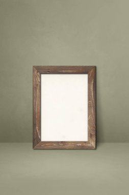 Gri bir duvara dayanan ahşap çerçeve. Boş model şablonu