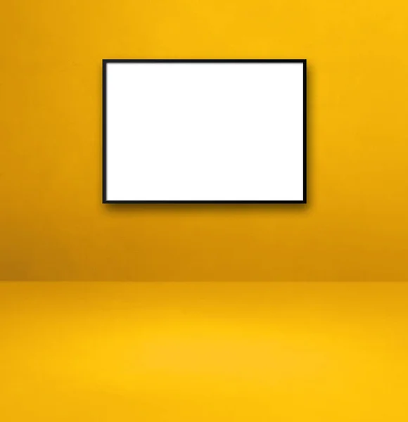 Black picture frame hanging on a yellow wall. Blank mockup template