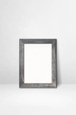 Tahta çerçeve beyaz bir duvara dayanıyor. Boş model şablonu