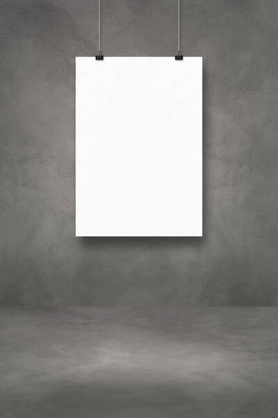 White poster hanging on a dark concrete wall with clips. Blank mockup template