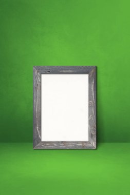 Tahta çerçeve yeşil bir duvara dayanıyor. Boş model şablonu