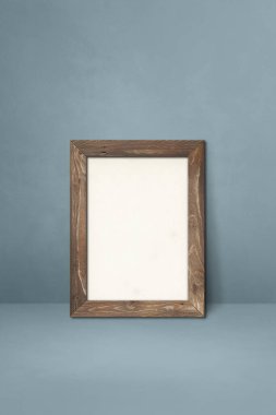 Gri bir duvara dayanan ahşap çerçeve. Boş model şablonu