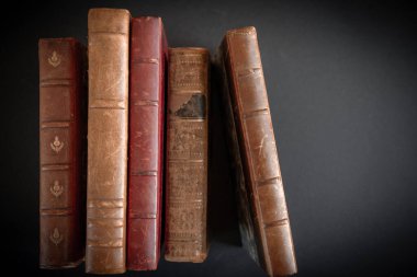 Siyah arkaplanda izole edilmiş eski kitapların satırı