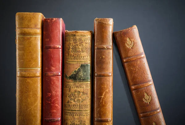 Row of old books isolated on dark background