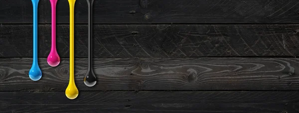 Cmyk墨水滴隔离在黑色木制背景上 横向横幅 说明1 — 图库照片