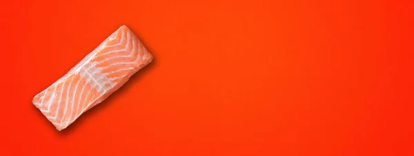 鲑鱼牛排用红色背景隔开 顶部视图 横向横幅 — 图库照片