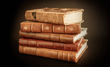 Siyah arkaplanda izole edilmiş eski kitapların yığını