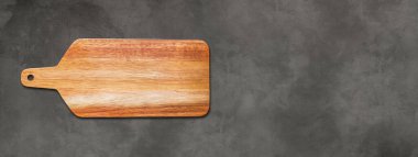 Tahta kesme tahtası koyu beton arka planda izole edilmiş. Yatay panoramik pankart