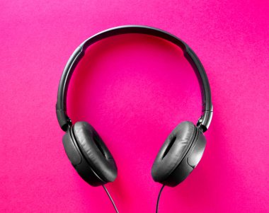 Pembe arka planda izole kulaklıklar.