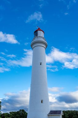 Avustralya 'daki Büyük Okyanus Yolu' ndaki Aireys Körfezi 'ndeki Split Point Deniz Feneri mavi bir gökyüzüne karşı dimdik ayakta duruyor. Beyaz kulesi ve bulutlarla kontrastlı kırmızı tepesi kıyı seyrüsefer simgesi görevi görüyor.