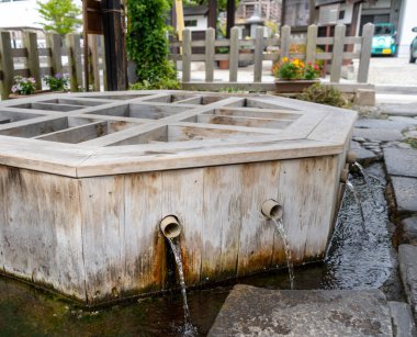 Kristal berrak kaynak suyu, Matsumoto 'daki geleneksel bir ahşap kuyudan tatlı bir şekilde akar ve büyüleyici bir ortamda ferahlık ve huzur sunar.