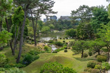 Bereketli ağaçlar, yansıtıcı bir gölet ve manikürlü yeşillik Japonya 'nın Hiroşima şehrinde huzurlu bir tarihi manzara olan Shukkei-en bahçesini dolduruyor.