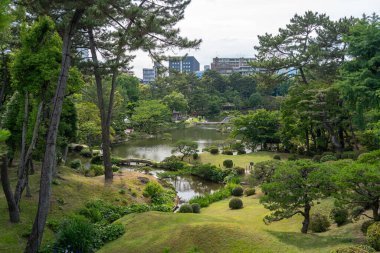 Bereketli ağaçlar, yansıtıcı bir gölet ve manikürlü yeşillik Japonya 'nın Hiroşima şehrinde huzurlu bir tarihi manzara olan Shukkei-en bahçesini dolduruyor.