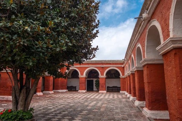 Santa Catalina Manastırı avlusu, canlı kırmızı duvarlar, ağaçlar ve çiçeklerle, sakin anlar için sakin bir alan sunar.