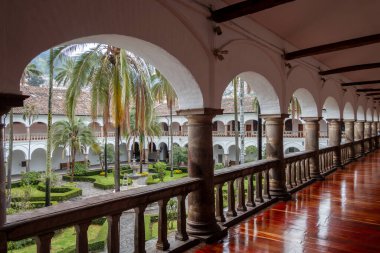Quito, Ekvador 'daki tarihi San Francisco manastırı ve kilise avlusunda koloni mimarisi, palmiye ağaçları ve sakin bir çeşme yer alıyor.