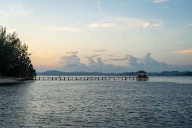 Bolilanga Adası, Togian takımadaları, Sulawesi, Endonezya 'nın sakin suları ve pastel gökyüzü üzerinde huzurlu bir günbatımı.