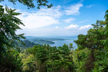 Tentena, Sulawesi, Endonezya yakınlarındaki açık mavi gökyüzünün altında yemyeşil tepeler ve ormanlarla çevrili Poso Gölü geniş bir görüş alanına sahiptir.