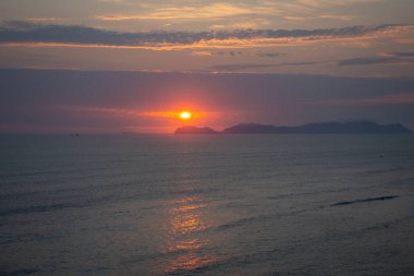 Güneş San Lorenzo adasının üzerinde batıyor, Pasifik Okyanusu 'na ve Peru' nun yeşil kayalıklarına altın bir parıltı saçıyor. Huzurlu kıyı manzarası doğanın güzelliğini ve huzurunu nefes kesici bir şekilde gösteriyor.