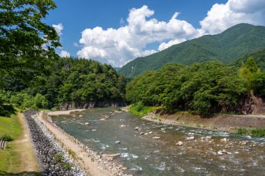 Sho Nehri, ormanlık dağlar ve huzurlu bir yaz manzarasında geleneksel sazdan evler ile çevrili Shirakawa-go 'da usulca esiyor.