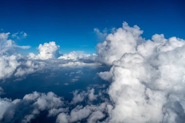 Görkemli beyaz bulutlar derin mavi Pasifik Okyanusu 'nun üzerinde yüzerler, Fransız Polinezyası üzerinde uçan bir uçaktan yakalanırlar. Nefes kesici yüksek irtifa perspektifi