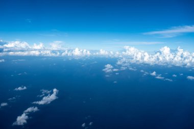 Görkemli beyaz bulutlar derin mavi Pasifik Okyanusu 'nun üzerinde yüzerler, Fransız Polinezyası üzerinde uçan bir uçaktan yakalanırlar. Nefes kesici yüksek irtifa perspektifi