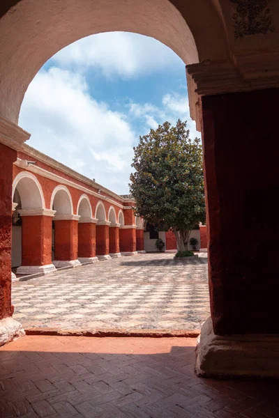 Santa Catalina Manastırı avlusu, canlı kırmızı duvarlar, ağaçlar ve çiçeklerle, sakin anlar için sakin bir alan sunar.