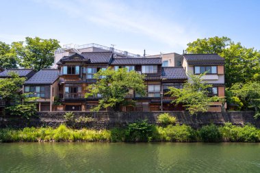 Geleneksel ahşap evler, Japonya 'nın Kanazawa kentindeki büyüleyici Kazue-machi bölgesini oluşturan Asano Nehri' nin huzurlu kıyılarına uzanır.