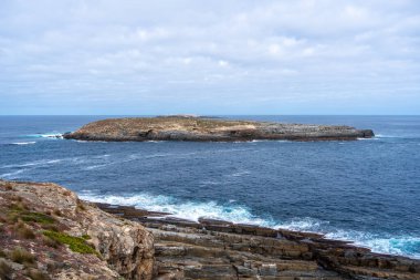 Flinders Chase Ulusal Parkı, Kanguru Adası, Avustralya 'daki Cape Du Couedic' te görülen Casuarina Adası 'nda kayalık kıyılar, mavi okyanus, kıyı bitkileri ve uzak ve vahşi bir arazide engebeli uçurumlar yer almaktadır.