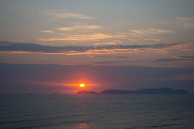 Güneş San Lorenzo adasının üzerinde batıyor, Pasifik Okyanusu 'na ve Peru' nun yeşil kayalıklarına altın bir parıltı saçıyor. Huzurlu kıyı manzarası doğanın güzelliğini ve huzurunu nefes kesici bir şekilde gösteriyor.
