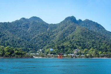 Miyajima 'nın ünlü yüzen torii kapısı Japonya' nın Hiroşima yakınlarındaki yemyeşil dağlarla çevrili körfezde duruyor.