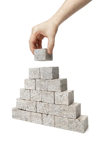 Hombre construcción de la pirámide de granito — Foto de Stock