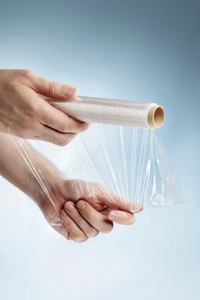 Man holding a roll of plastic film — Stock Photo, Image