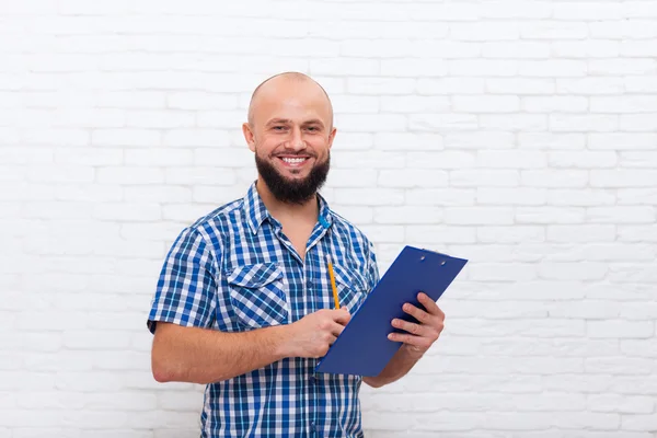 Lässiger bärtiger Geschäftsmann, der eine Mappe mit Bleistiftdokumenten in der Hand hält und glücklich lächelt — Stockfoto