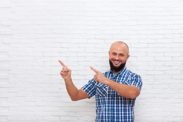 Casual barbuto uomo sorridente punto dita fino a copiare lo spazio — Foto Stock