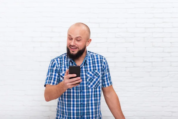 Casual barbudo homem de negócios surpreendido segurando celular inteligente — Fotografia de Stock