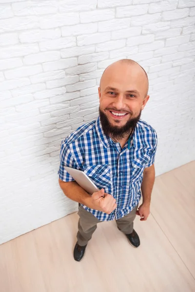 Випадковий бородатий чоловік використовує планшетний комп'ютер Щаслива посмішка вид зверху — стокове фото