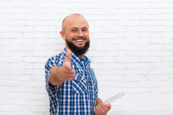 カジュアルなひげの男は、タブレットコンピュータを保持し、手ぶれ挨拶を保持します — ストック写真