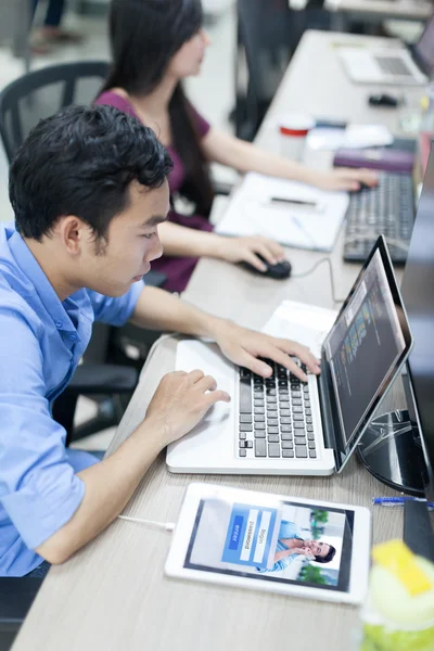Desenvolvedor de software asiático usando computador portátil — Fotografia de Stock