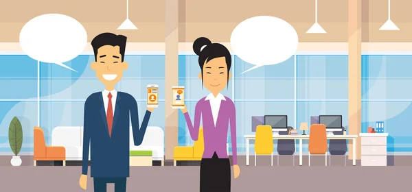Homme d'affaires asiatique et femme tiennent la bulle de chat de téléphone intelligent cellulaire dans le bureau moderne — Image vectorielle