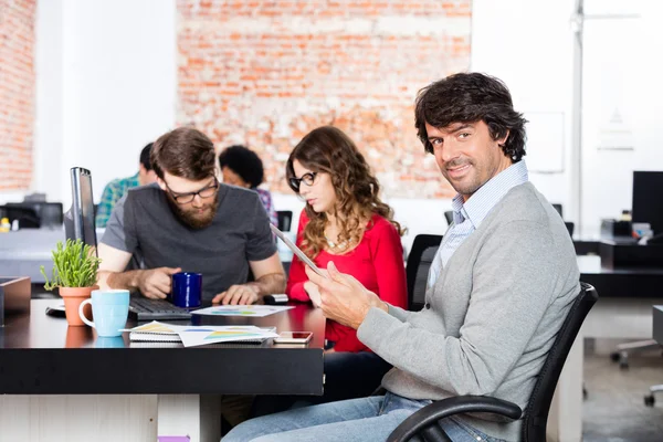 Casual człowiek za pomocą tabletu siedzi pracy biurowej, ludzi biznesu — Zdjęcie stockowe