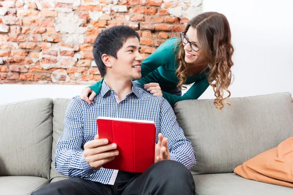 Aziatische man zitten op coach met behulp van Tablet vrouw glimlach — Stockfoto