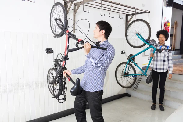 Mensen hangen fiets op muur Office diverse mix race — Stockfoto